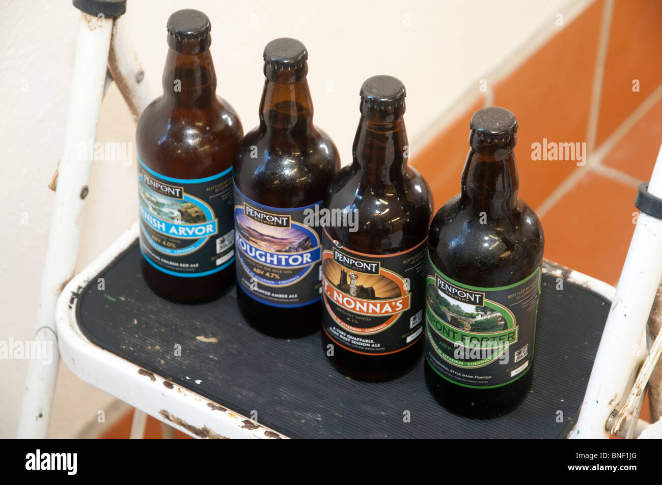 Range of bottled beers from Penpont brewery, Cornwall, displayed on a white step-ladder in the brewery Stock Photo