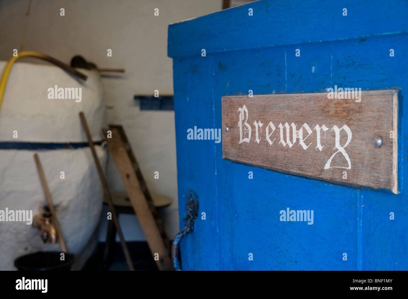 Door with sign to the Spingo brewery, at the Blue Anchor brewpub in Helston, Cornwall, with some brewing equipment visible. Stock Photo