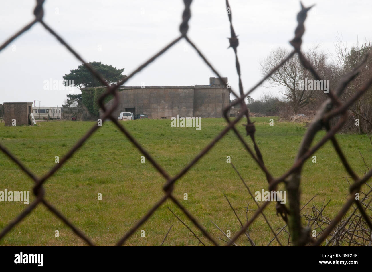 Old 1960s nuclear bunker, now the home of Lizard Ales brewery, in Cornwall, viewed through the old, rusty security fence. Stock Photo
