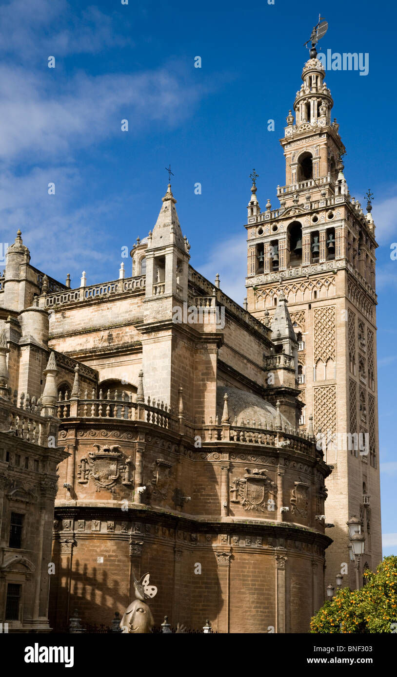 The Giralda tower (former mosque minaret converted into bell tower) in Seville / Sevilla, & side of Seville Cathedral. Spain. Stock Photo