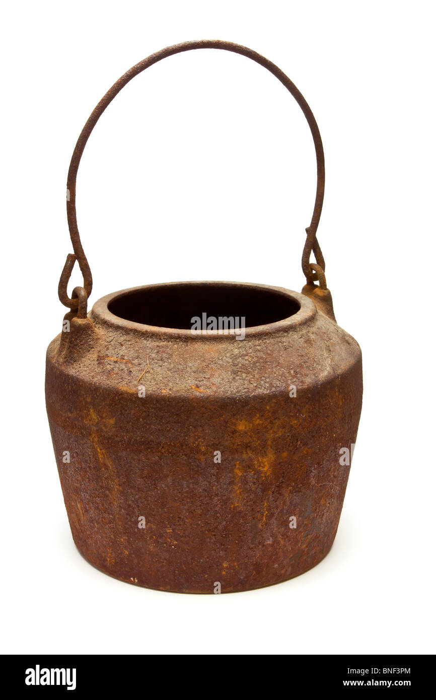 Old rusty cast iron pot / cauldron from low perspective isolated against white. Stock Photo