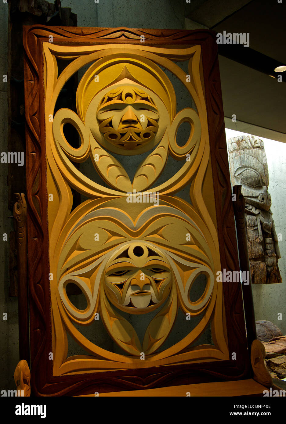 Modern carved cedar west coast Aboriginal First Nations ceremonial dual face masks screen at UBC Museum of Anthropology Stock Photo