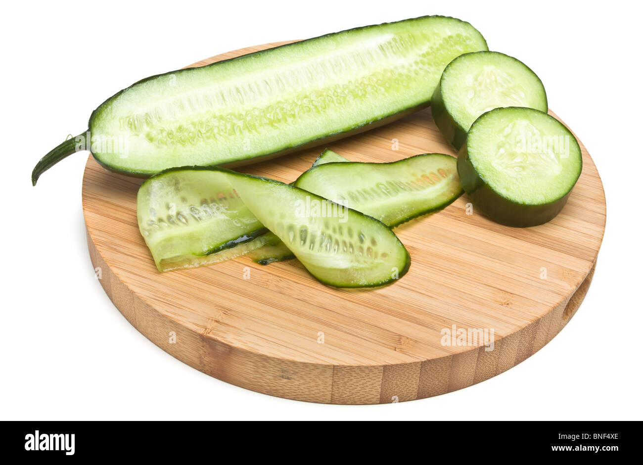 Sliced ribbons of Cucumber from low perspective on wooden bamboo chopping board. Stock Photo