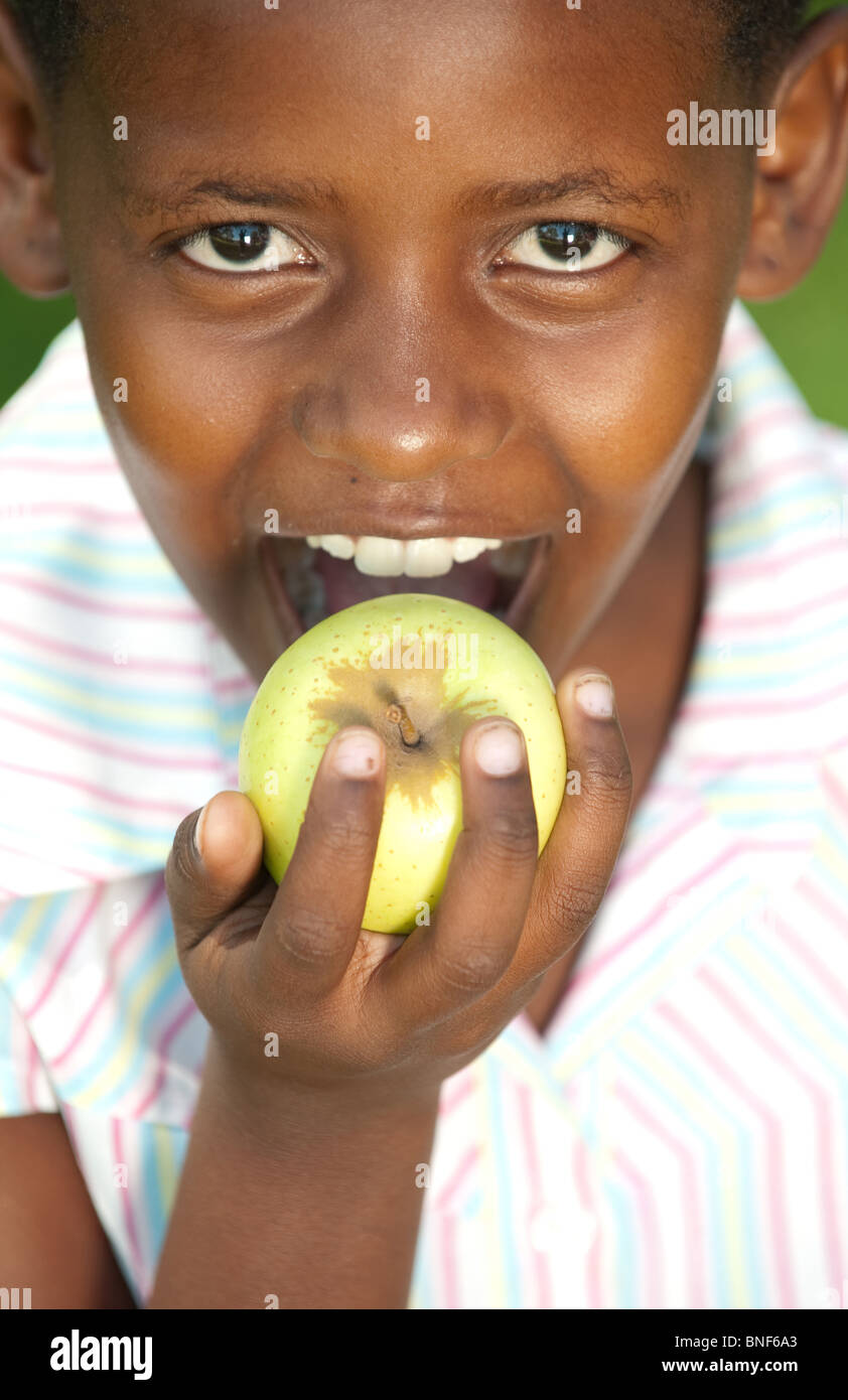 Portrait of girl (8-9) biting apple, Johannesburg, Gauteng Province, South Africa Stock Photo