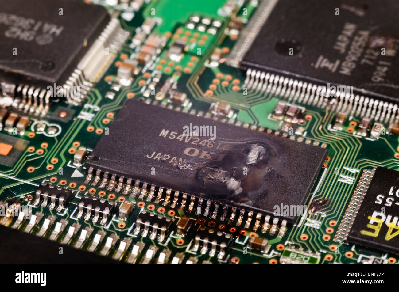 Electronic integrated circuit (IC) on a computer PCB after suffering a catastrophic static discharge and burn out Stock Photo