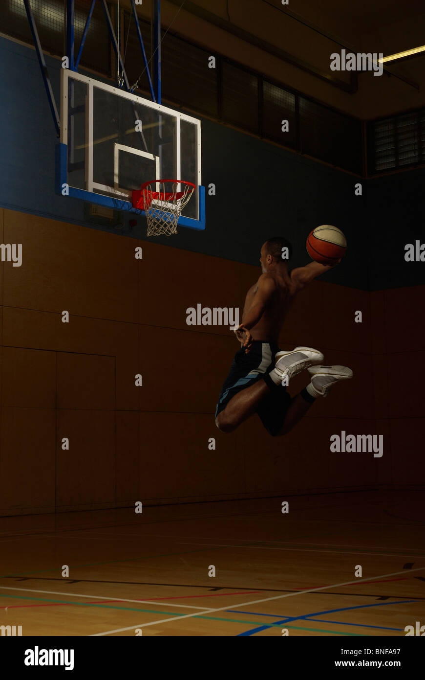 Basketball player jumping at goal hoop Stock Photo Alamy