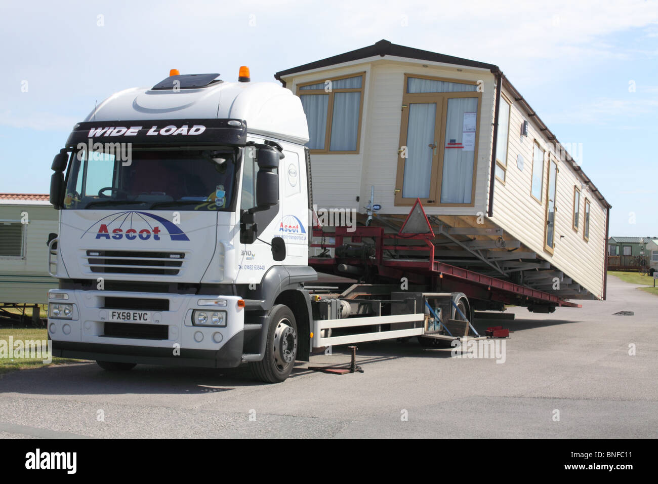 flat-bed lorry unloading a new static caravan at a campsite on Walney Island, Barrow-in-Furness, Cumbria Stock Photo