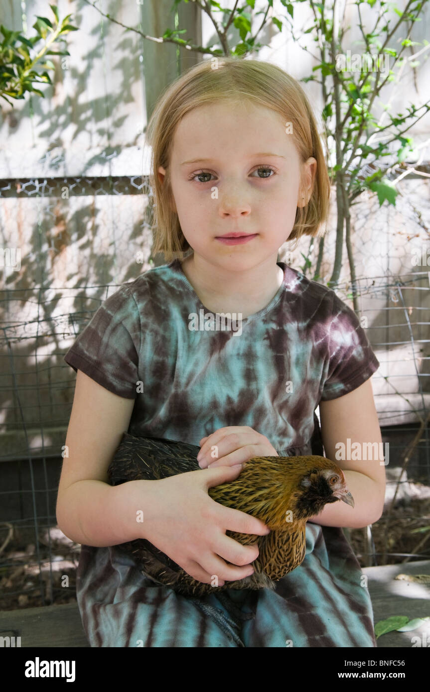 girl holding chicken from urban backyard chicken coup Stock Photo