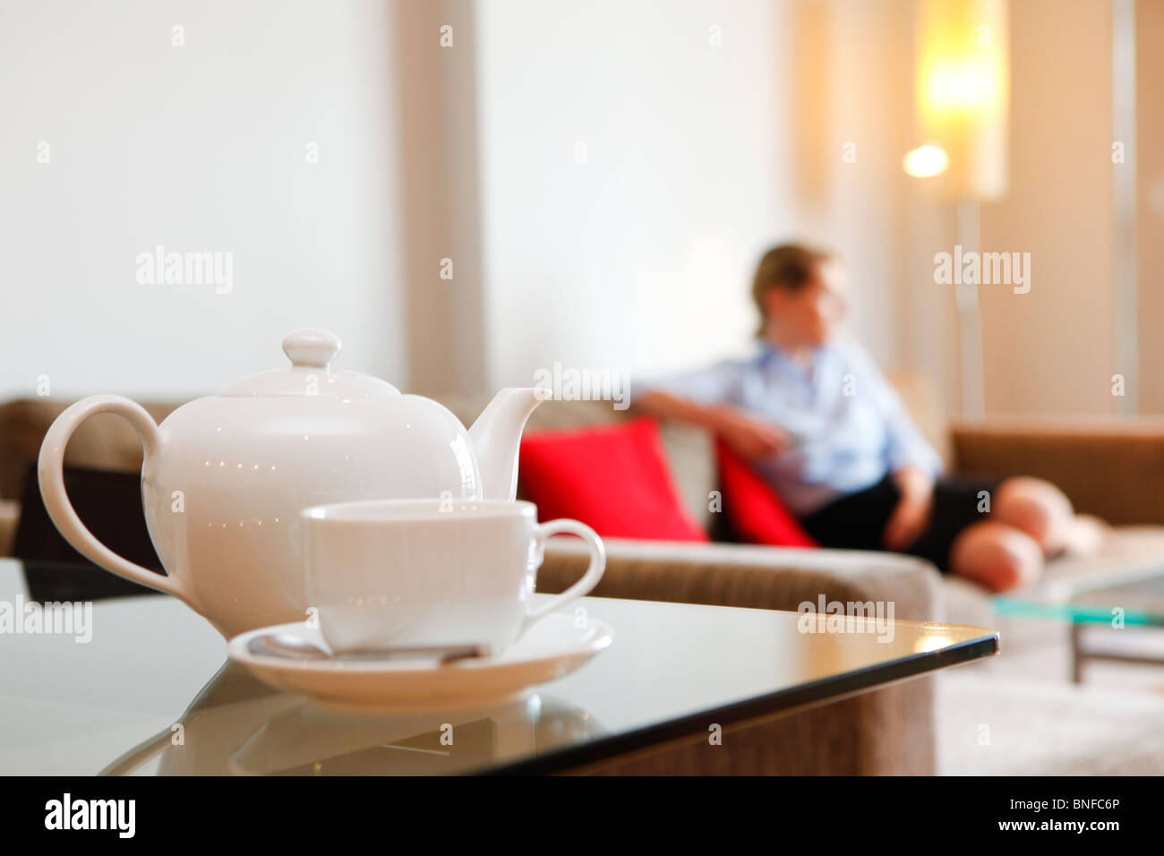 Woman sitting on sofa watching TV in apartments Stock Photo