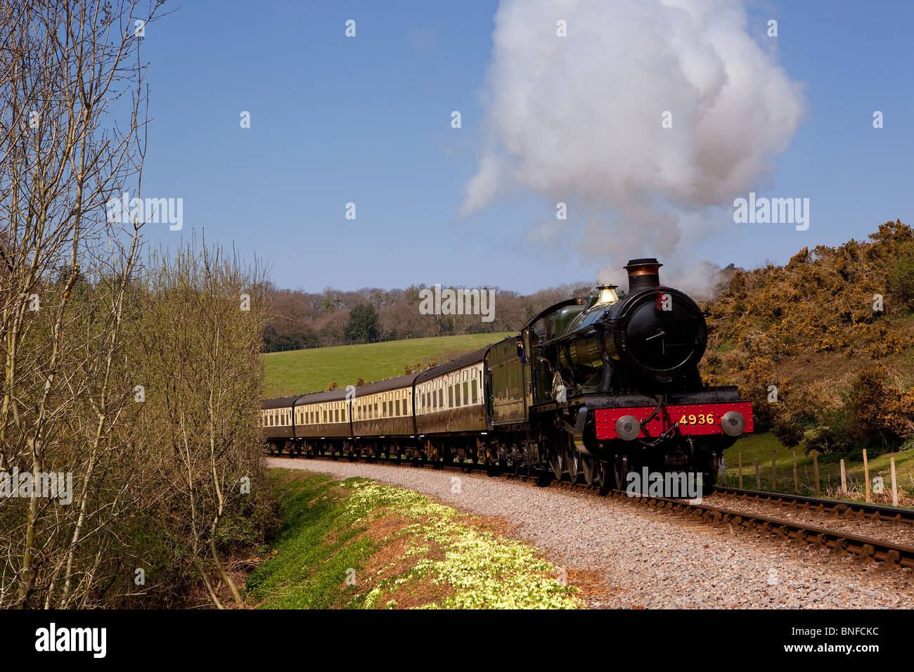 4936 'Kinlet Hall' passes Stones Wood on the West Somerset Railway, UK Stock Photo