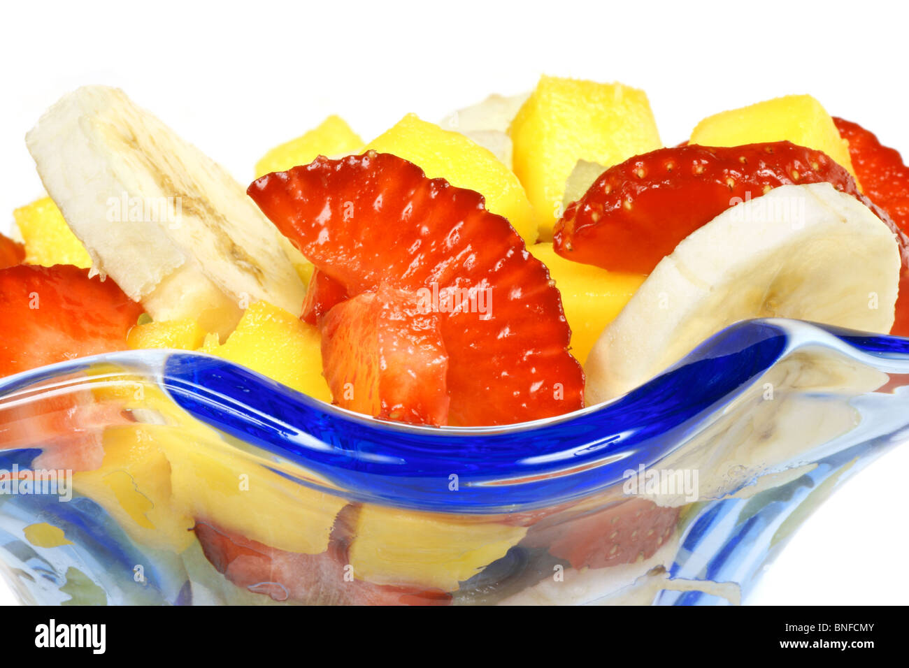 Close-up of a colorful fresh fruit salad in a blue glass cup. Stock Photo