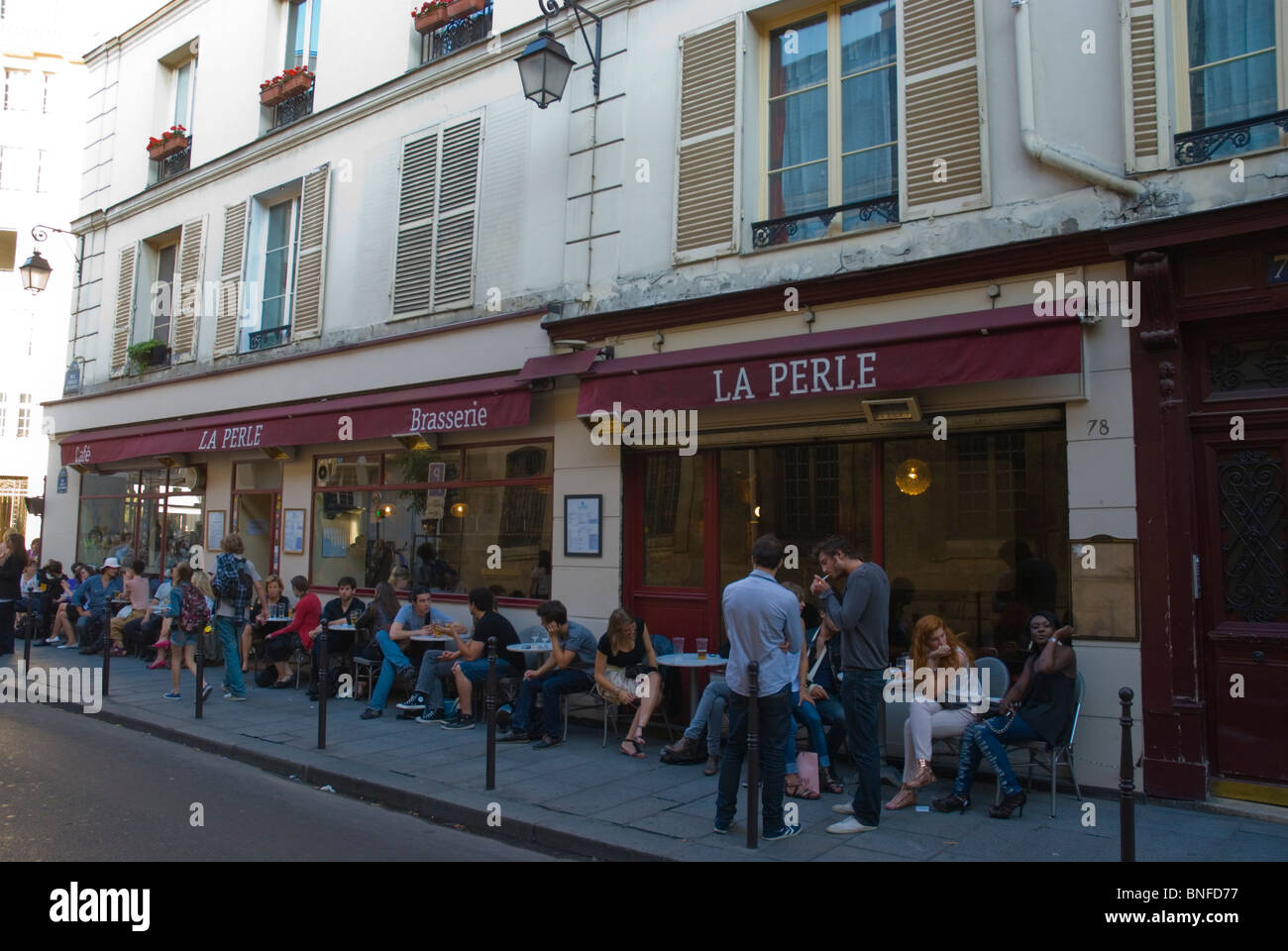 Young people outside a brassiere La Perle in Le Marais district Paris France Europe Stock Photo