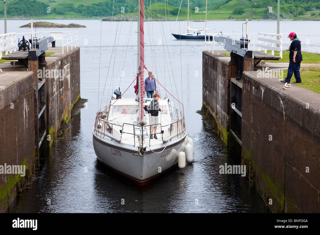 Yacht enters the first sea lock on the  Crinan canal Stock Photo