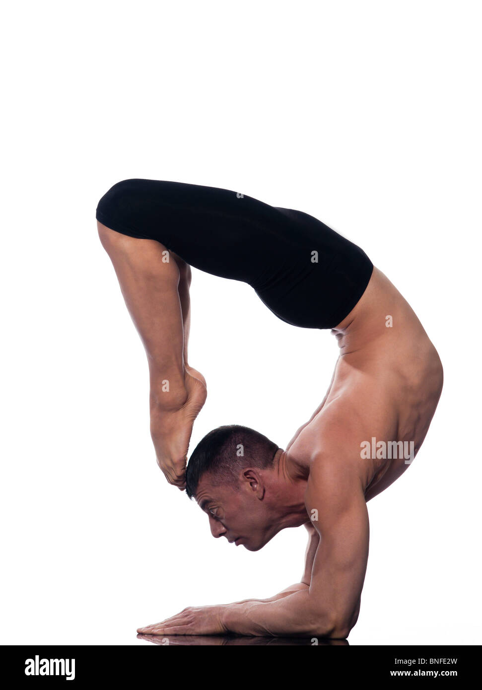 caucasian man scorpion pose Vrschikasana gymnastic acrobatics isolated studio on white background Stock Photo