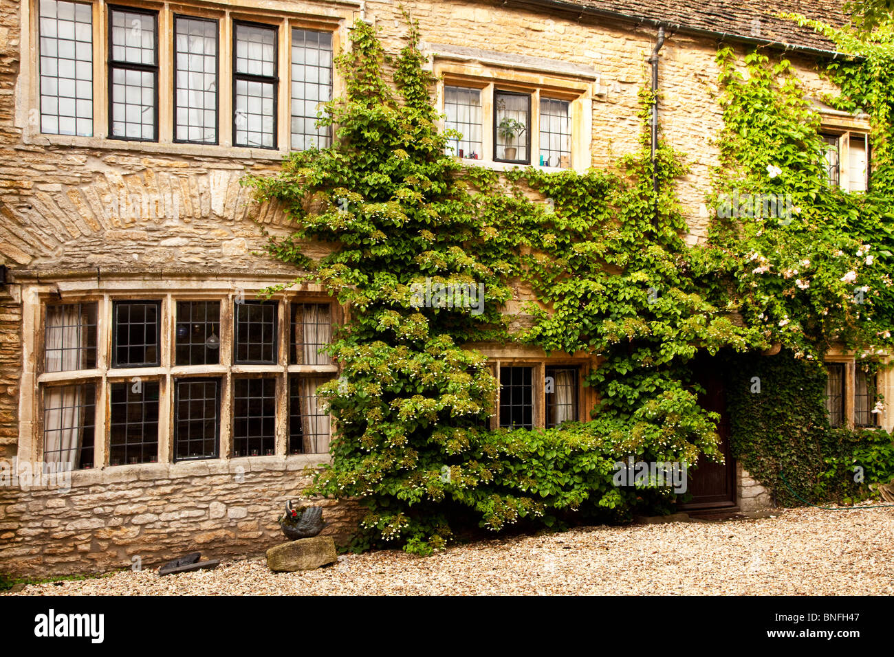 Old Cotswold stone cottage with mullioned windows and leaded lights in
