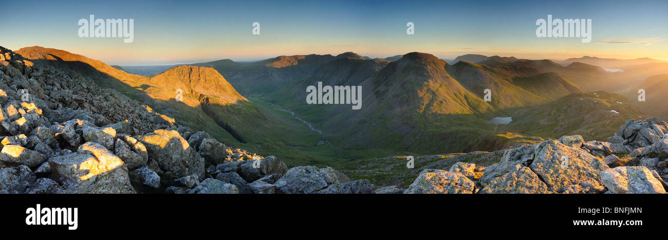 Shafts of dawn summer sunlight striking mountains in the English Lake District. Panoramic view including Lingmell & Great Gable Stock Photo