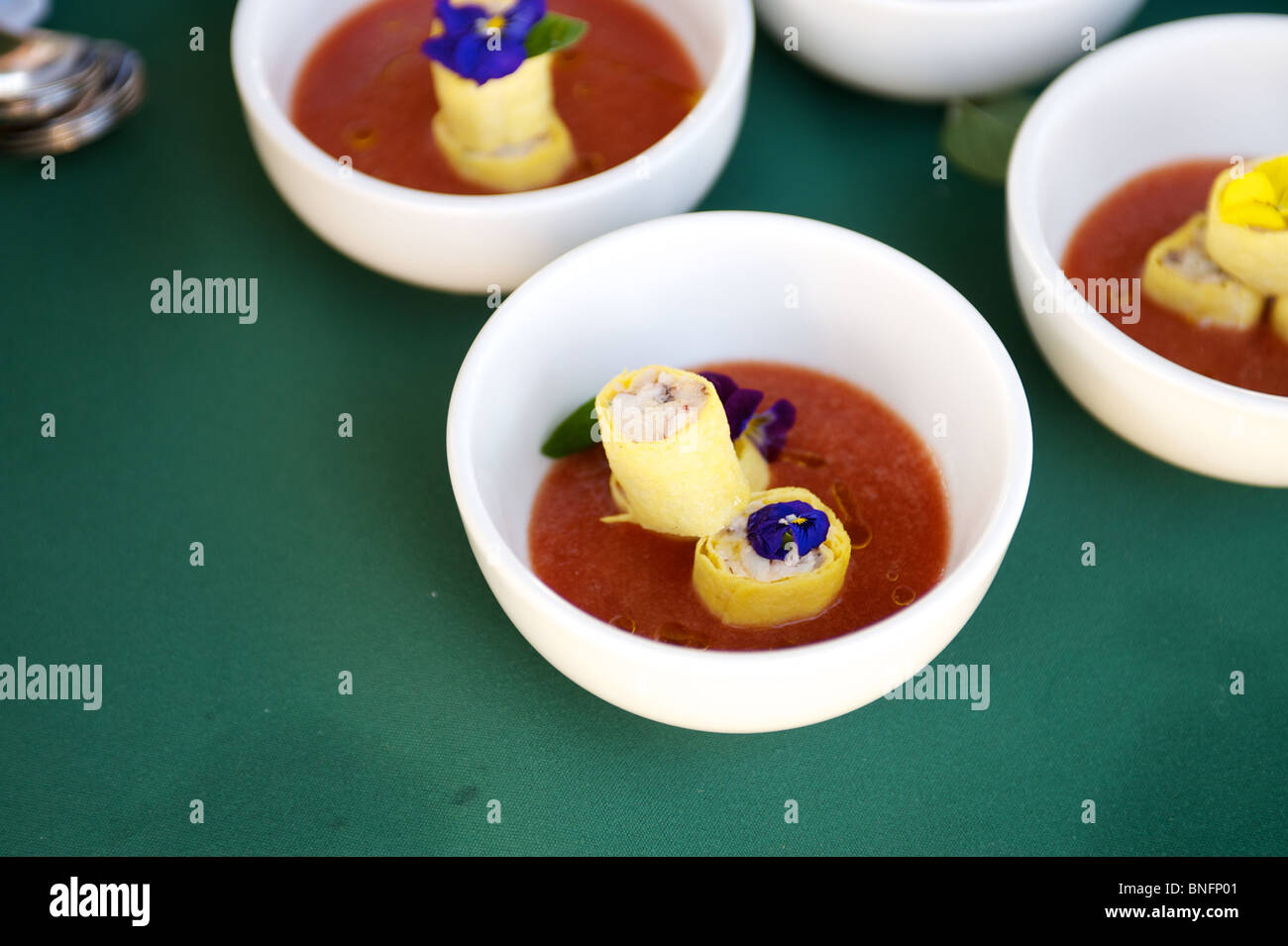 Crab cakes and gazpacho soup hors d'oeuvre being plated by a chef. Outstanding in the Field, Pemberton BC, Canada Stock Photo