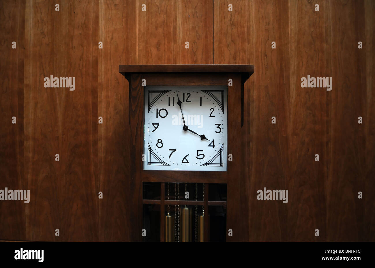 Modern clean grandfather clock against wooden wall Stock Photo