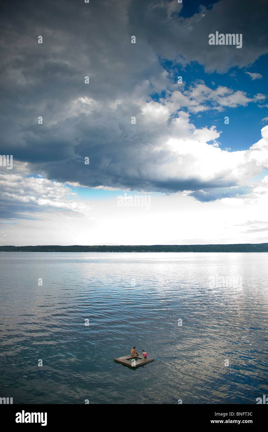 Two women on a float in a lake, Cayuga Lake, Ithaca, New York State, USA Stock Photo