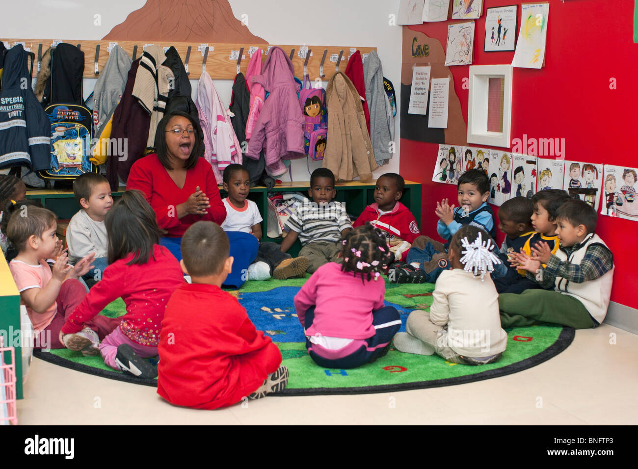 Preschool teacher singing with her students Stock Photo - Alamy