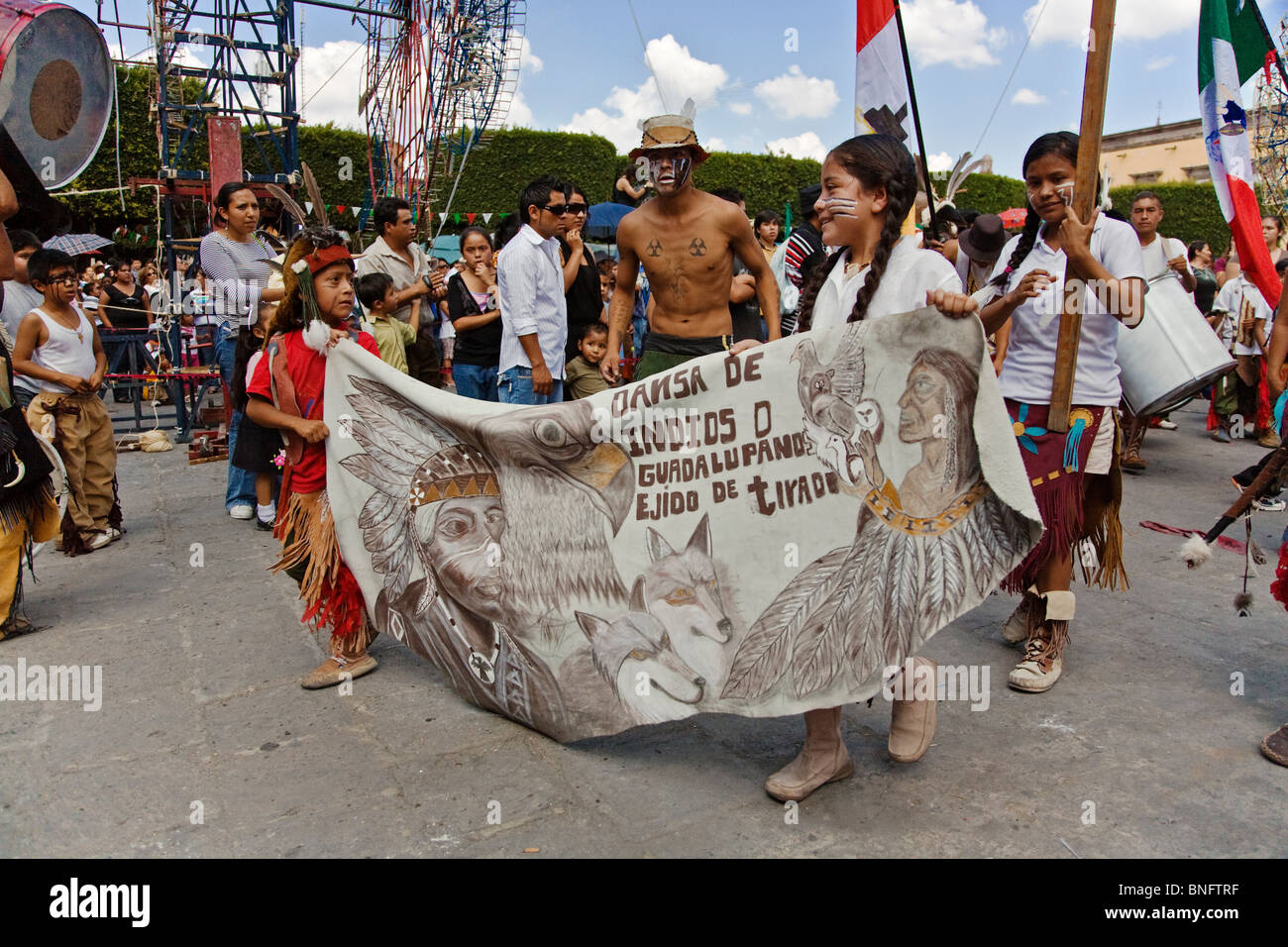 Indigenous children walk with a banner in the annual INDEPENDENCE DAY PARADE in September - SAN MIGUEL DE ALLENDE, MEXICO Stock Photo