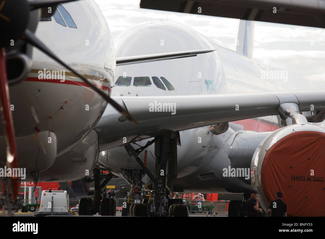 Security staff and static display aircraft lined-up at the Farnborough Airshow, the A380 at the back and a 777 in front. Stock Photo