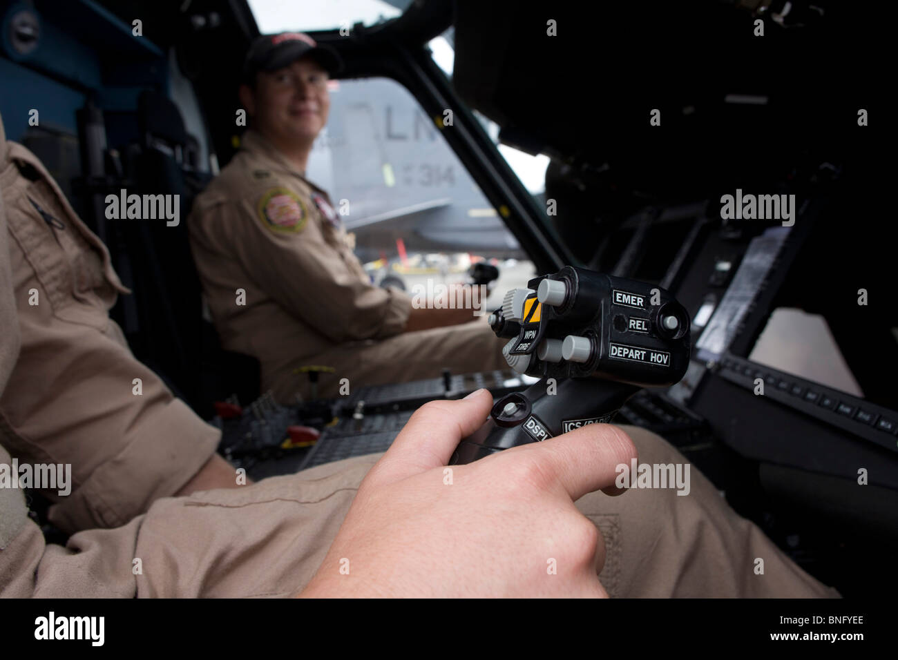 US Navy pilot grasps cyclic stick in the cockpit of a Sikorsky MH-60R helicopter at the Farnborough Airshow. Stock Photo