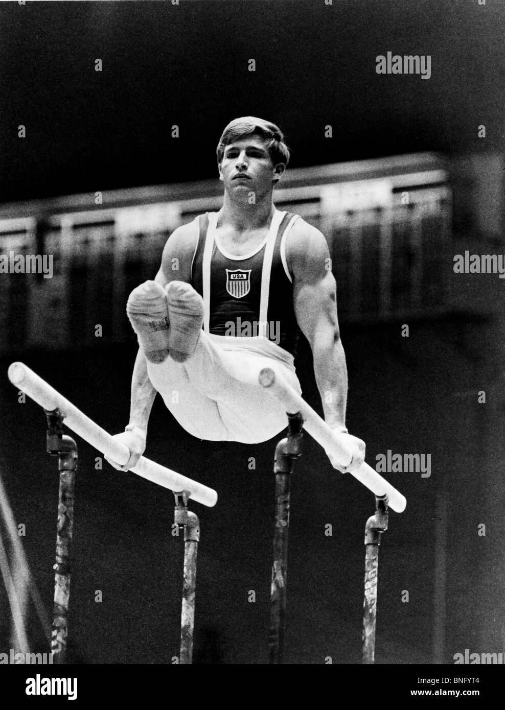 Young man performing on parallel bars at the Olympic games Stock Photo