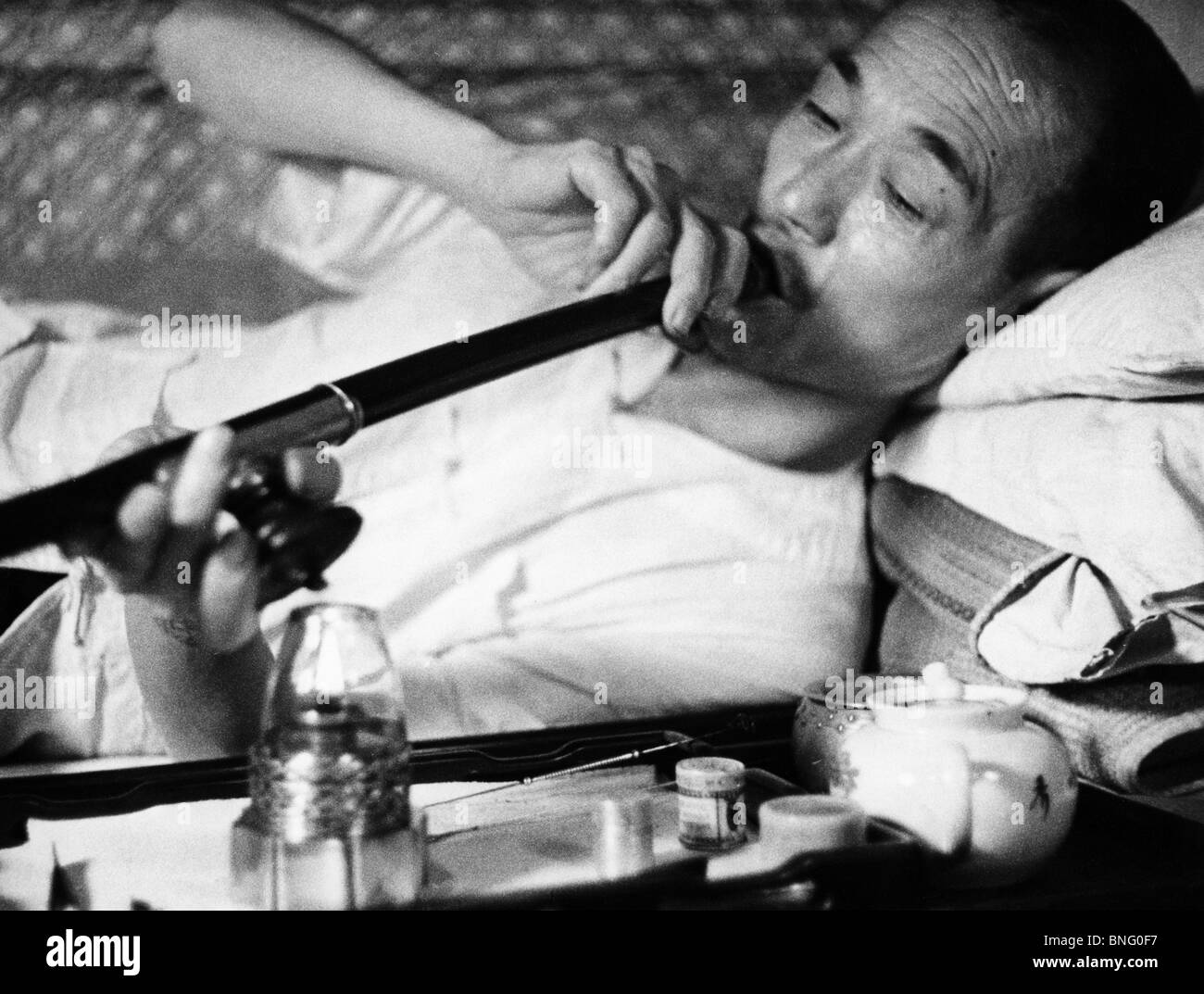 Mature man smoking opium Stock Photo