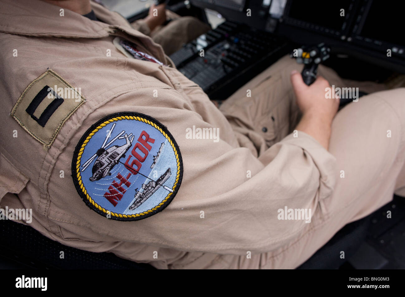 US Navy pilot grasps cyclic stick in the cockpit of a Sikorsky MH-60R helicopter at the Farnborough Airshow. Stock Photo