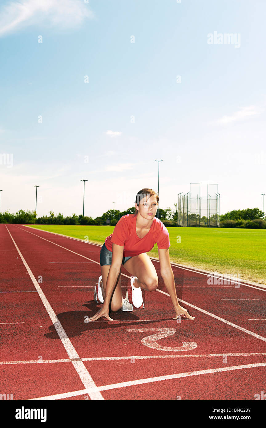 Female sprinter in starting blocks Stock Photo - Alamy