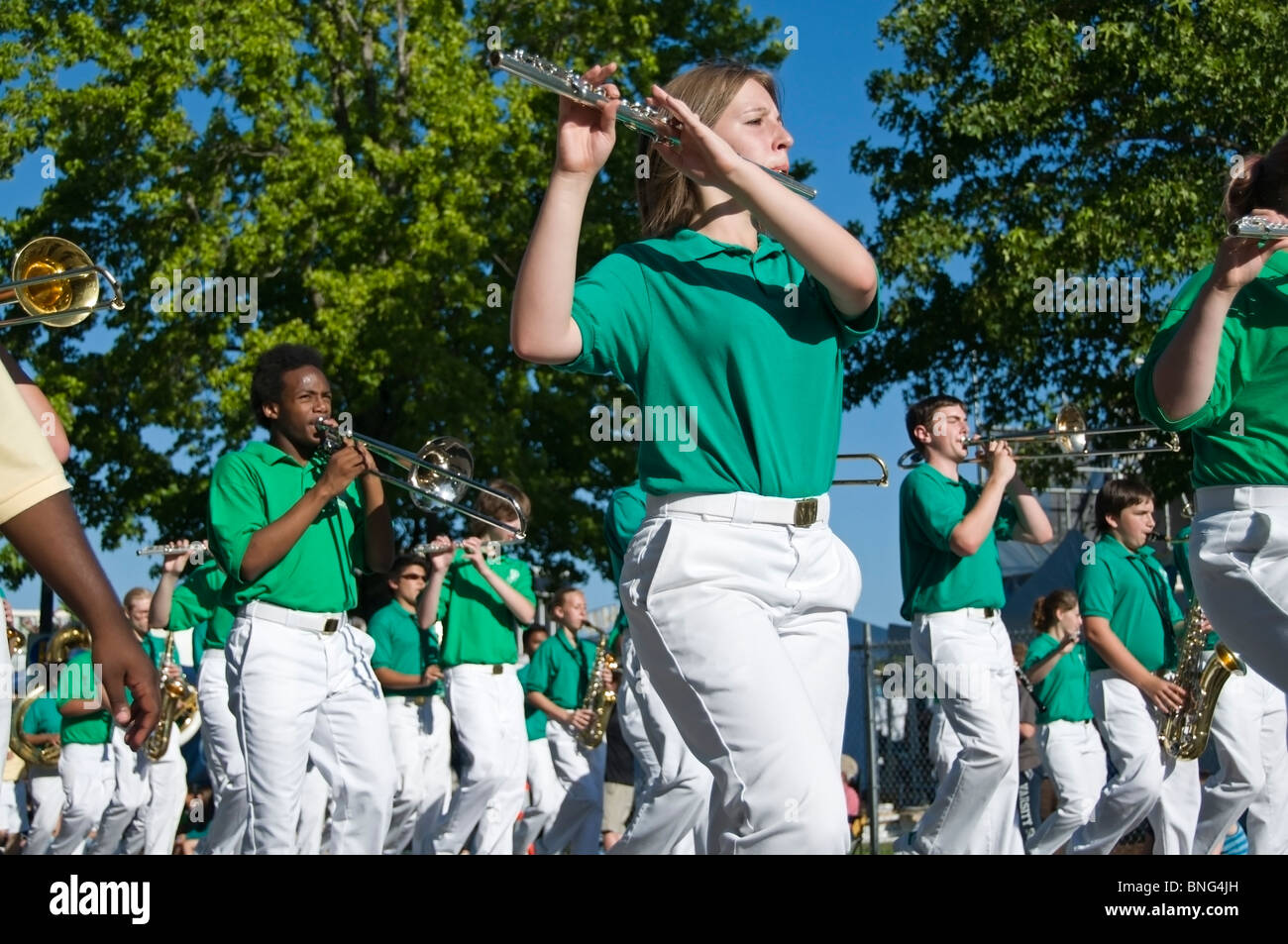 A female member of the Seattle All-City Marching Band plays her flute while marching in Olympia's Grand Parade during Lakefair Stock Photo