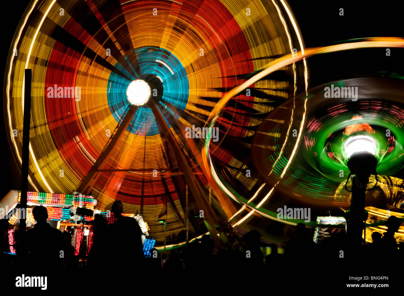 Amusement Park Rides Spin And Turn Displaying Bright Colors On A Stock Photo Alamy