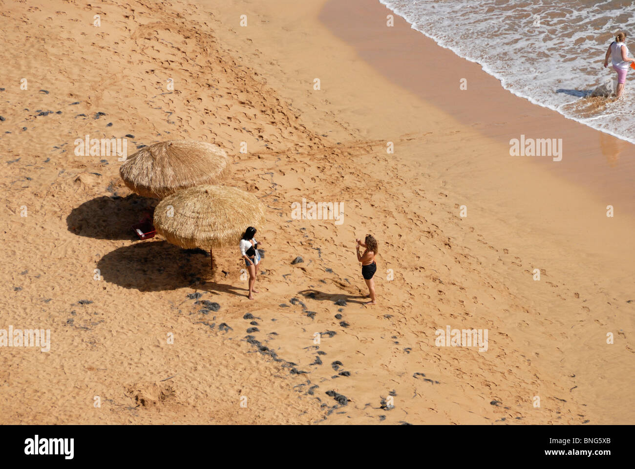 Two women on the beach, photographing each other, Liquillo, Puerto Rico Stock Photo