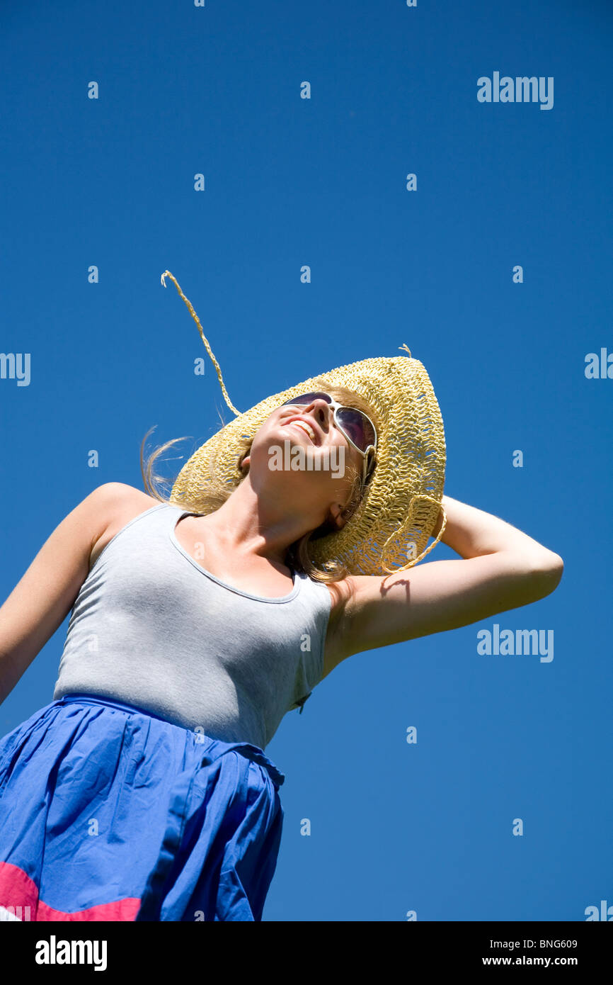 Girl with straw hat and sunglasses jumping Stock Photo Alamy