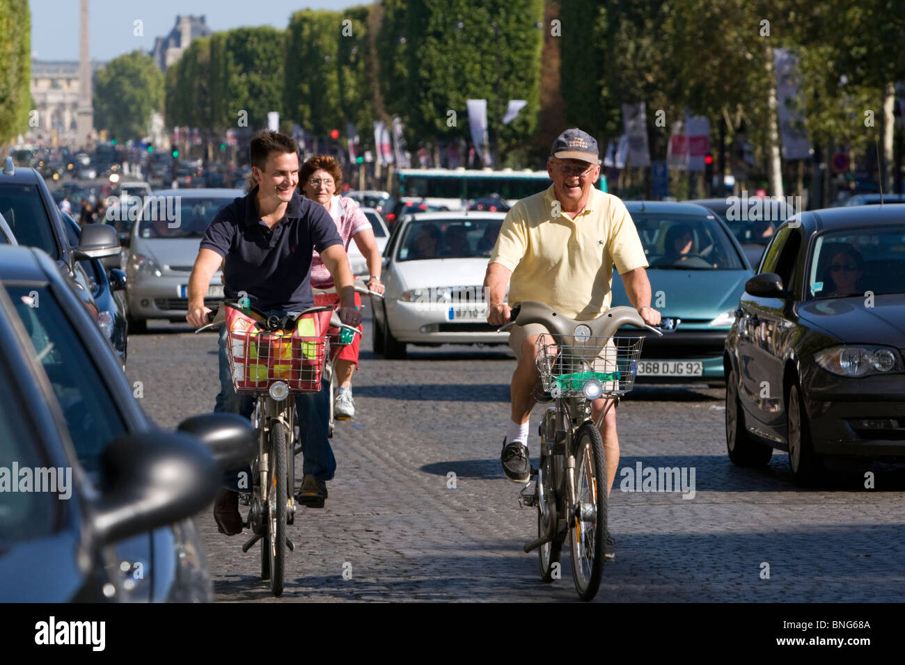 People ride bicycles along the Avenue des Champs-Elysees in Paris, France. Stock Photo
