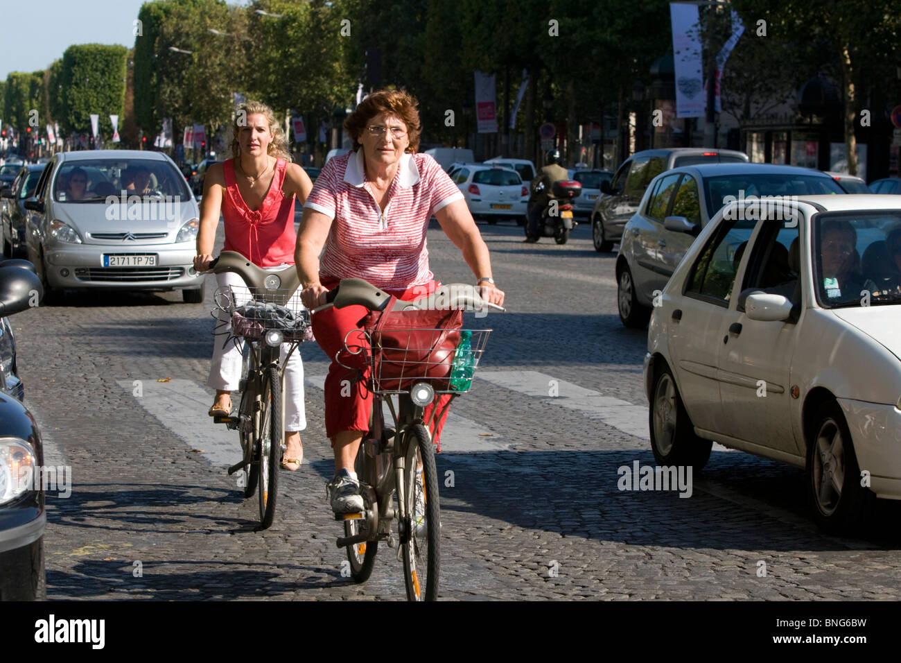 People ride bicycles along the Avenue des Champs-Elysees in Paris, France. Stock Photo