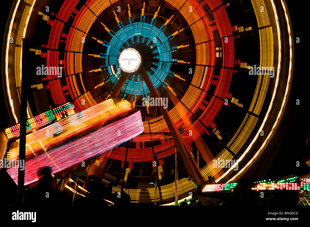 Amusement park rides spin and turn displaying bright colors on a summer night during Lakefair in Olympia, Washington. Stock Photo