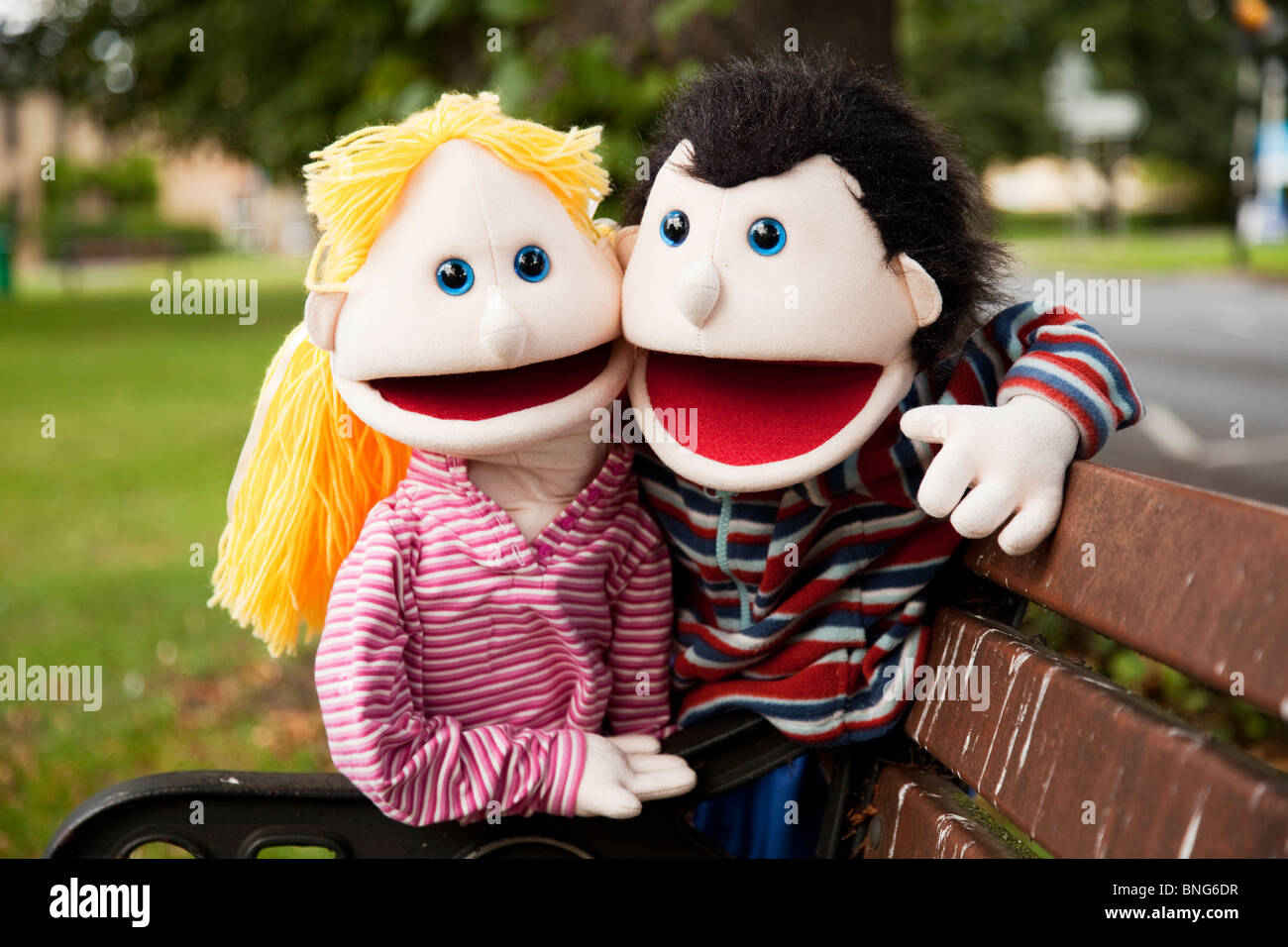 Amusing puppets couple on a park bench. Stock Photo
