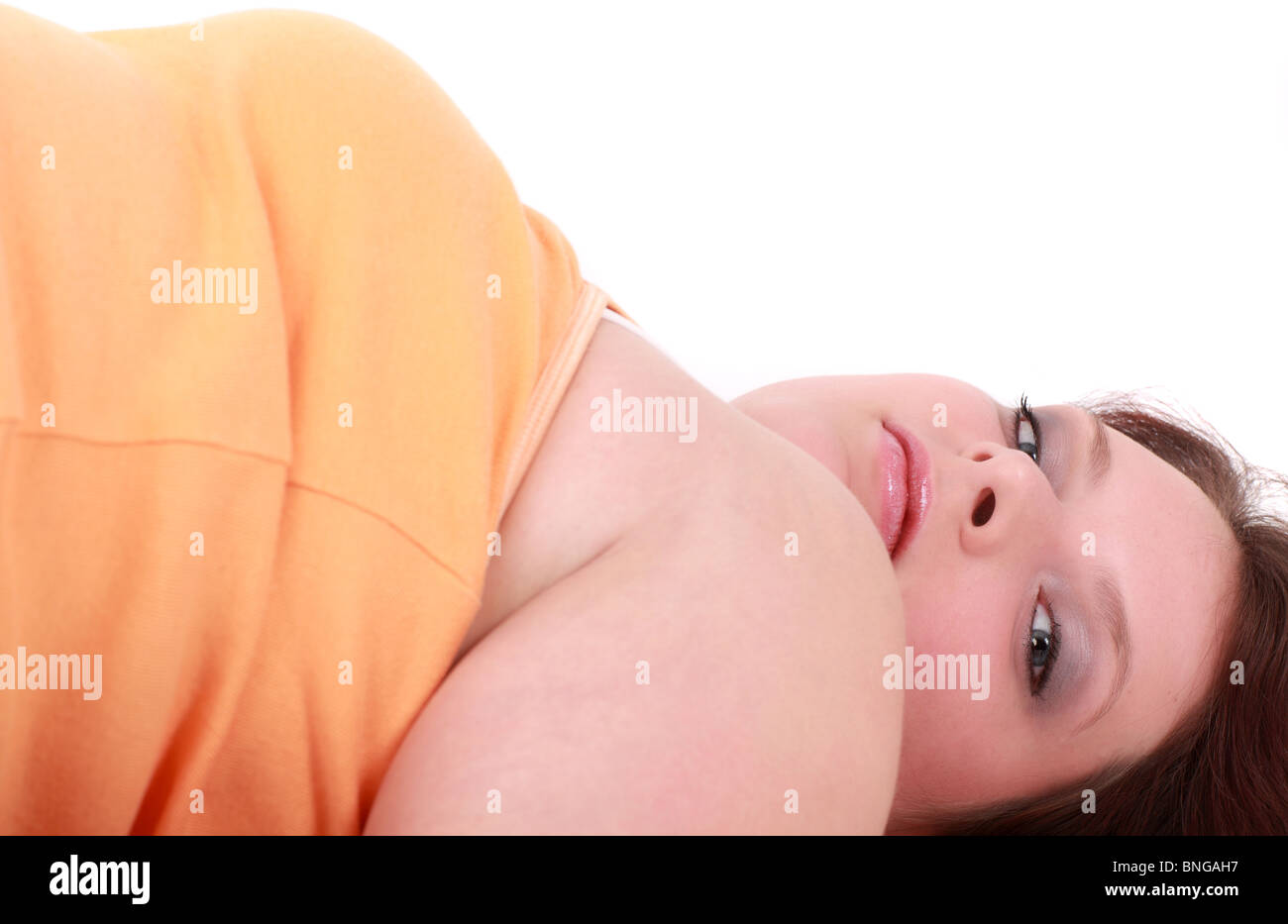 Portrait of teenage girl lying and looking at camera, studio shot Stock Photo