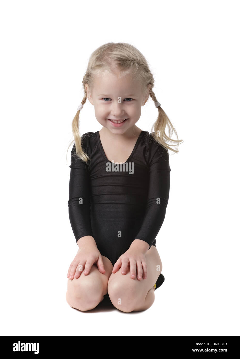 little gymnast girl sitting on knees isolated on white Stock Photo