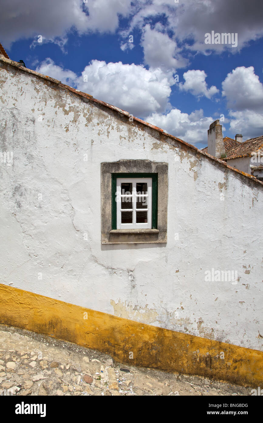 Rustic Green Window against a Whitewashed Wall with a Yellow Border. Stock Photo