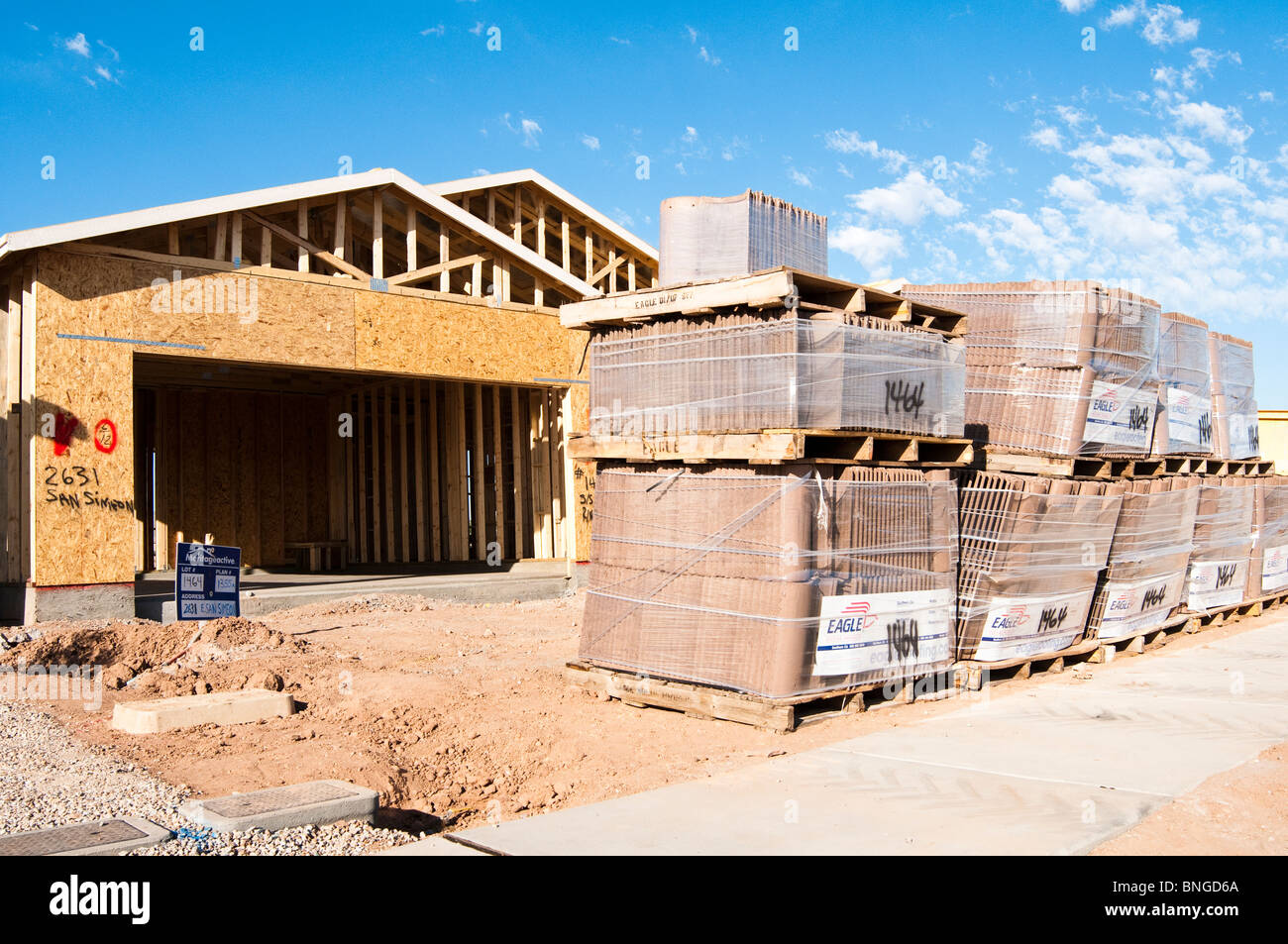 Roofing tiles are stacked on the construction site for a new wood frame house begin built in Arizona. Stock Photo