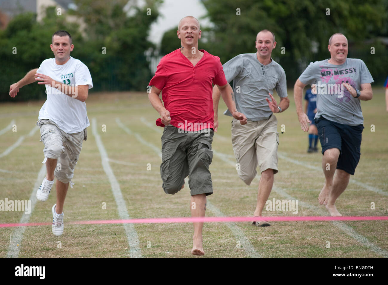 Competitive Dads sprint for the line in the parents race at the end of a traditional end of term school sports day Stock Photo
