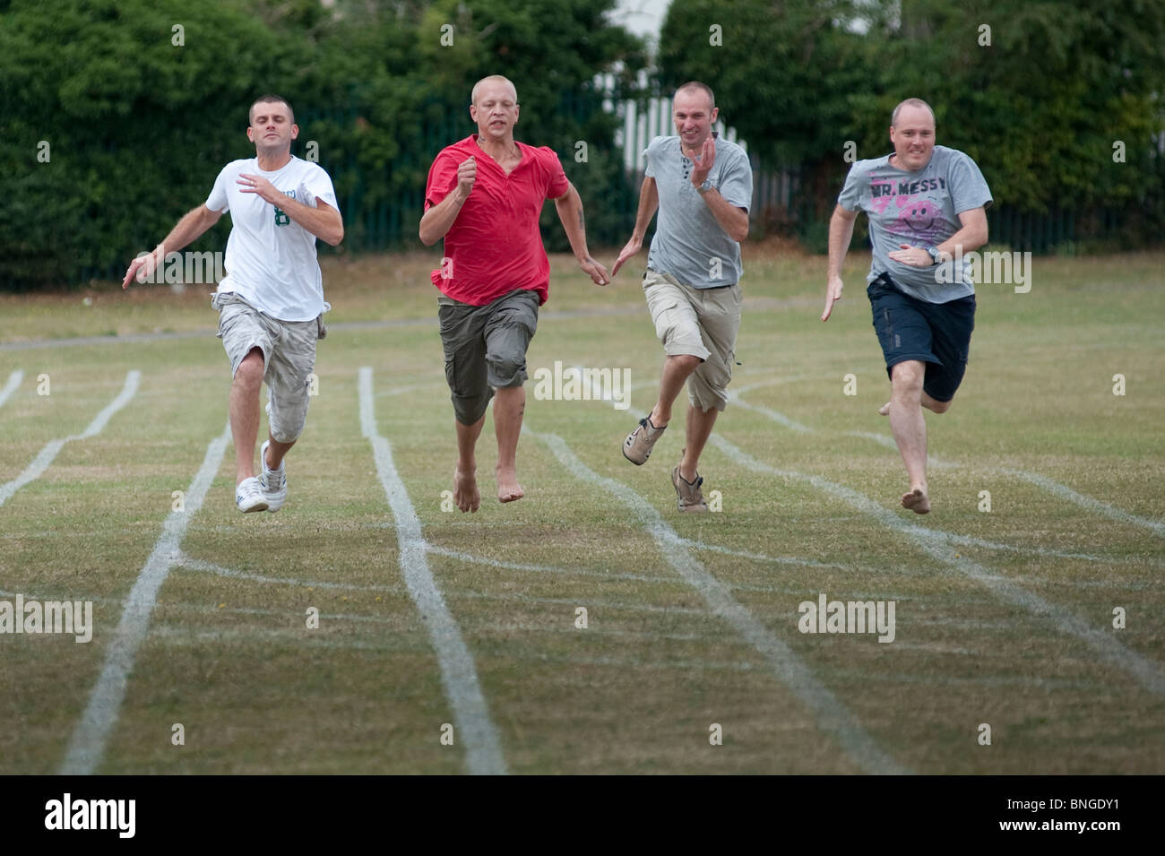 Competitive Dads sprint for the line in the parents race at the end of a traditional end of term school sports day Stock Photo