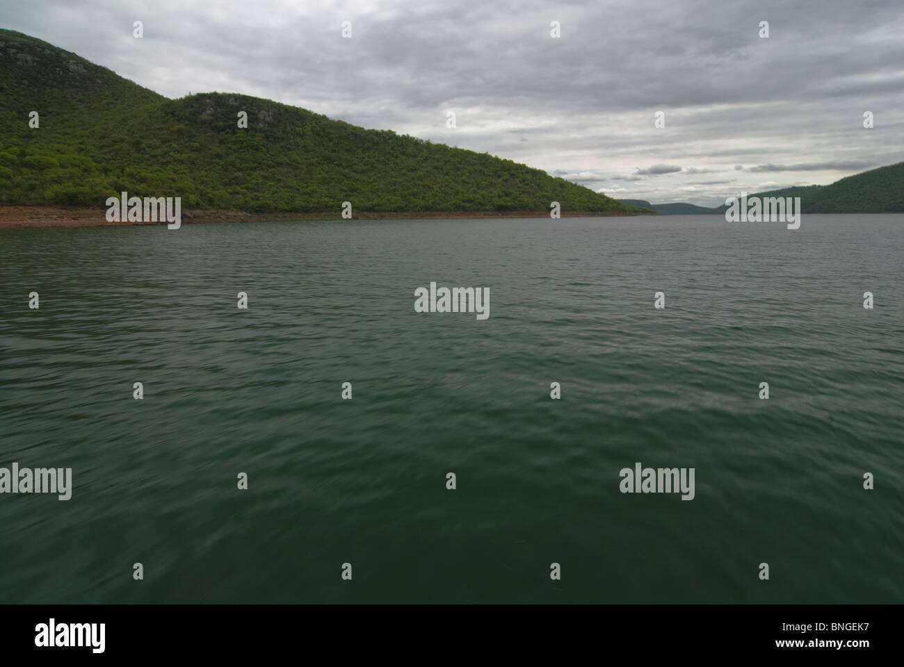 Motion blur of water with tree covered landmass and stormy clouds. Boat ride on Lake Jozini, Phongolo River, Kwazulu-Natal, South Africa. Stock Photo