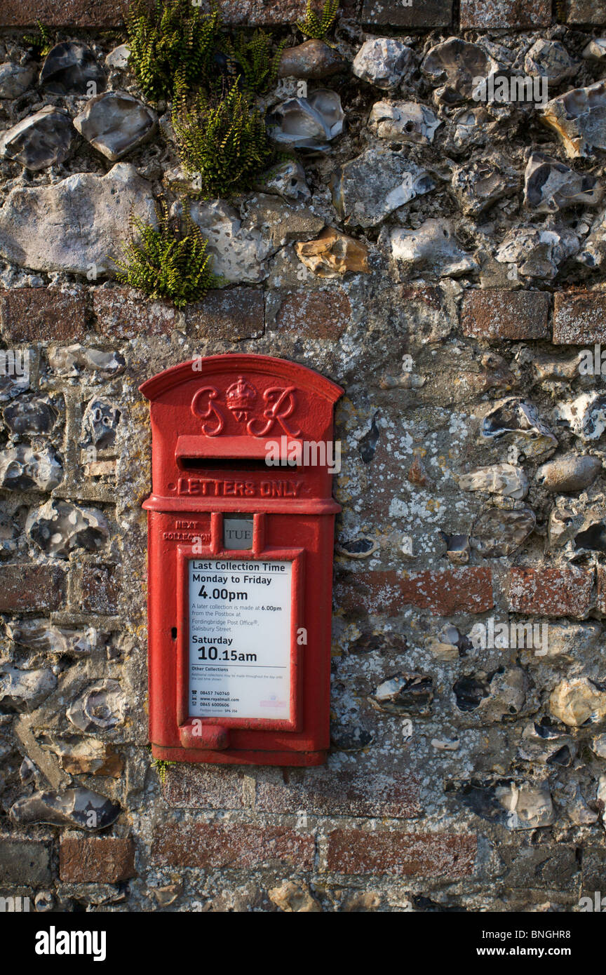 A traditional English flint and brick wall with its in-built post box. Stock Photo