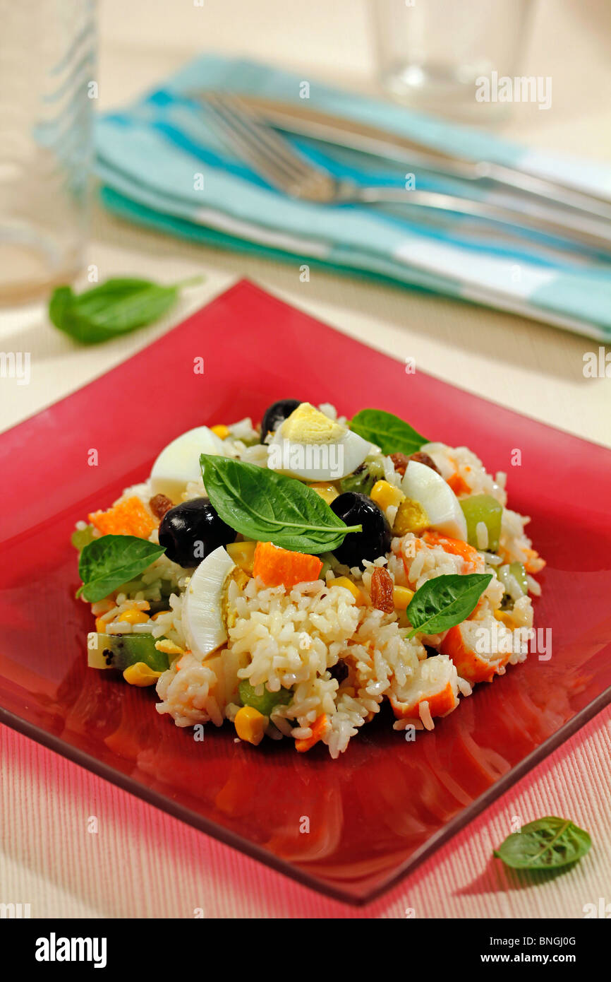 Rice salad with kiwifruit and surimi. Recipe available. Stock Photo