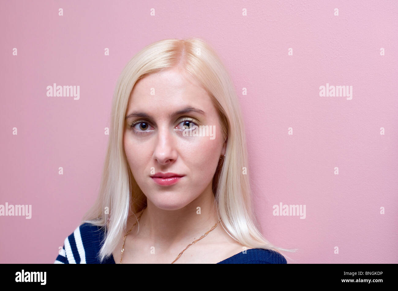 Portrait of a young woman in front of a pink background Stock Photo - Alamy