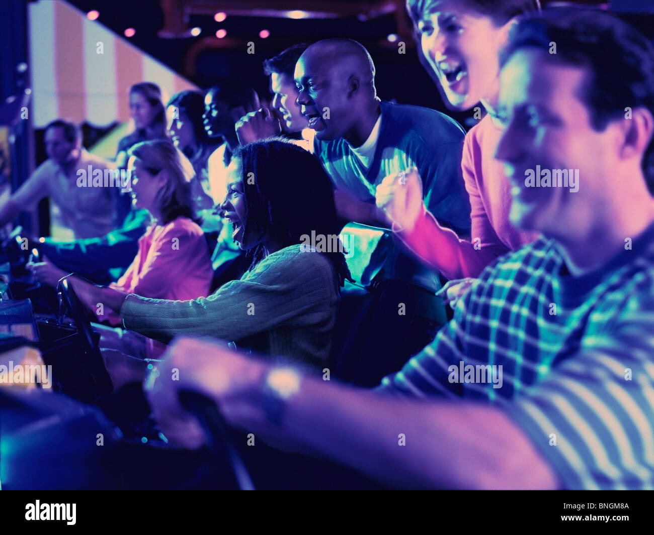 People playing video games in an amusement arcade Stock Photo - Alamy